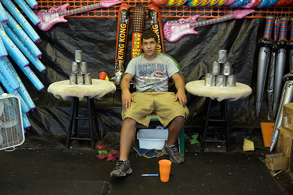 Young man working in a carnival booth, Starke County Fair, Hamlet